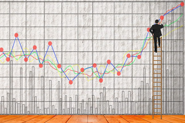 Woman's hand leading green arrow trending up on line graph