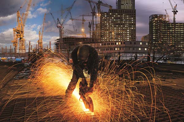 Construction worker cutting steel on construction site