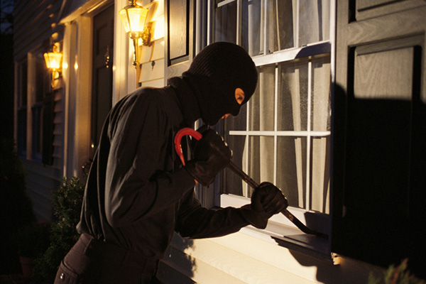 Person in ski mask pyring window open with crowbar
