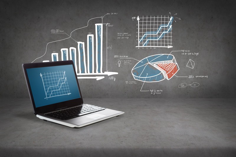 A laptop with different types of graphs in background
