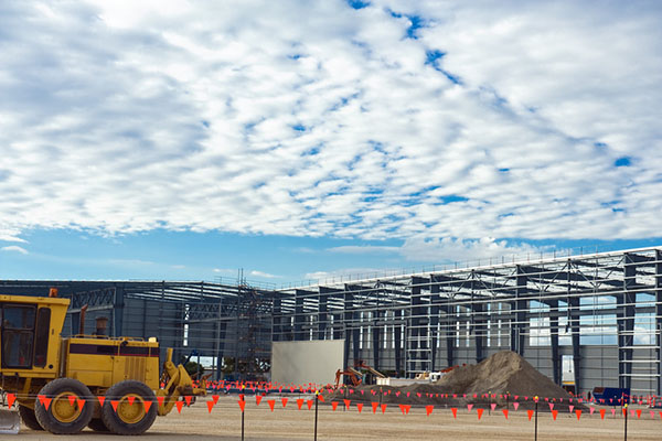 Red Flags mark industrial construction site with a yellow bulldozer