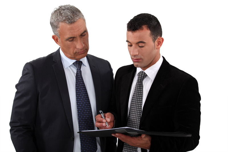 Businessmen looking at clipboard