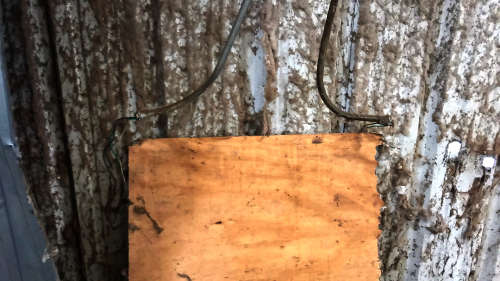 Exposed electrical wiring, missing electrical panel covers with fiber accumulation on energized components