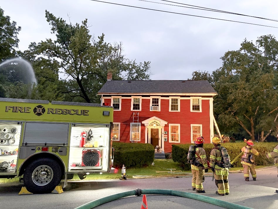 fire rescue truck and firemen at red two-story house