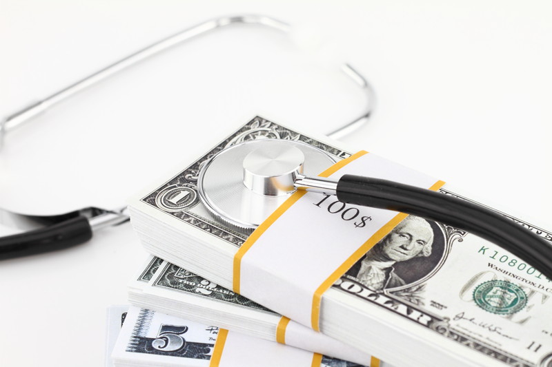 Stethoscope on top of stacks of money