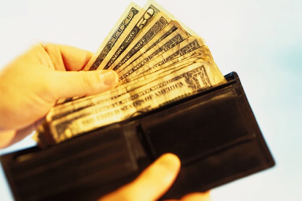 Hands pulling cash out of wallet