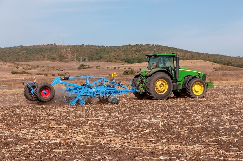 Tractor pulling a cultivator on a farm field