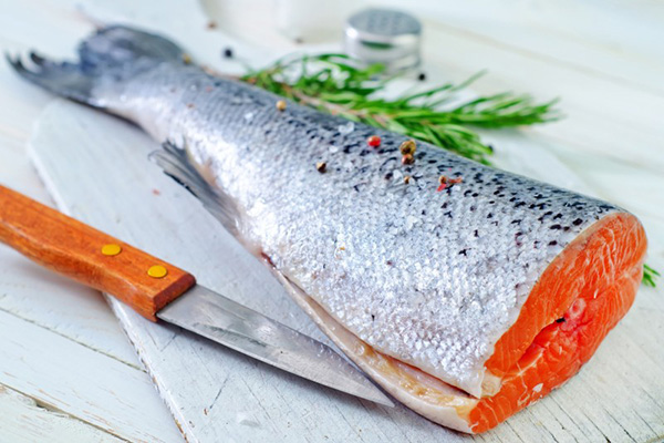 Salmon being cut open with knife