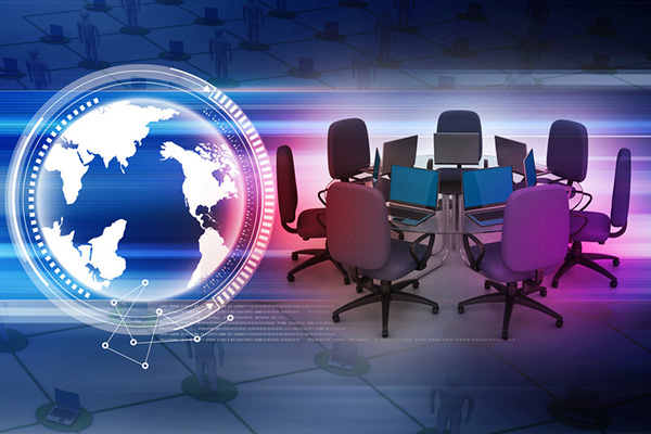 A white globe on the left with a circular table surrounded by chairs and laptops on the right