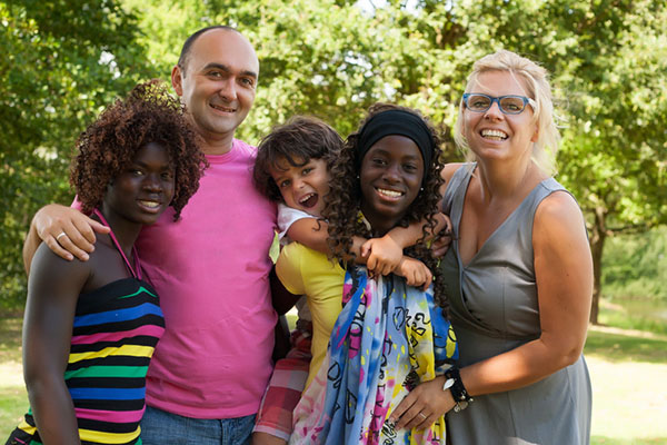 Smiling blended family of mom and dad with two daughters and a son