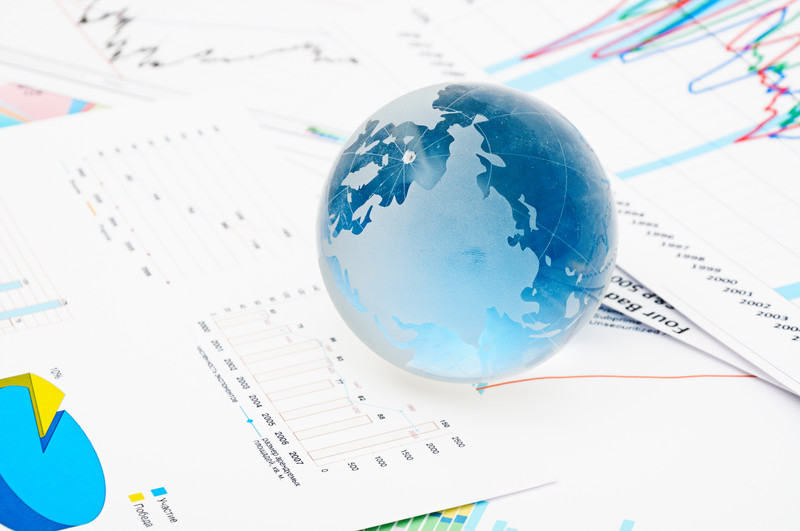 Globe on top of financial charts and graphs
