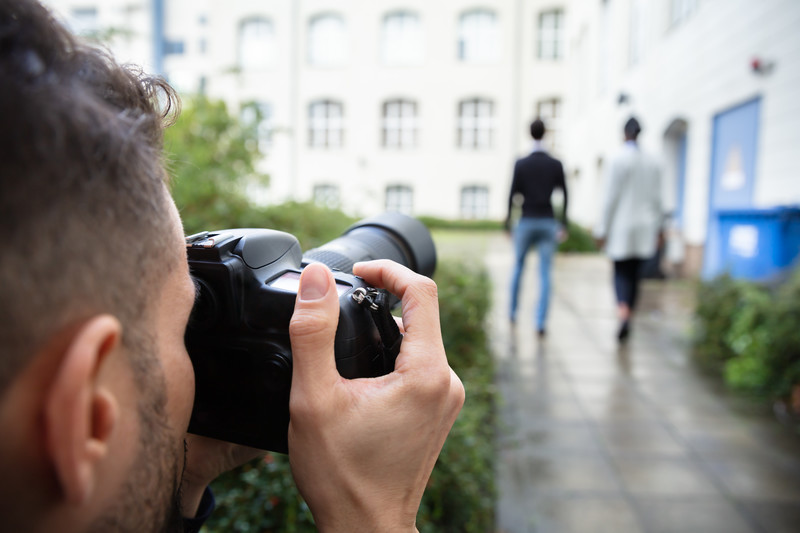 Paparazzi photographing couple