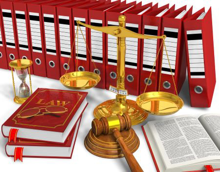 Wooden gavel in front of red law books, a gold hourglass, and a gold scale