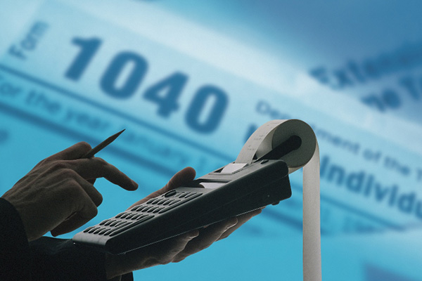 Hand using calculator in front of 1040 form