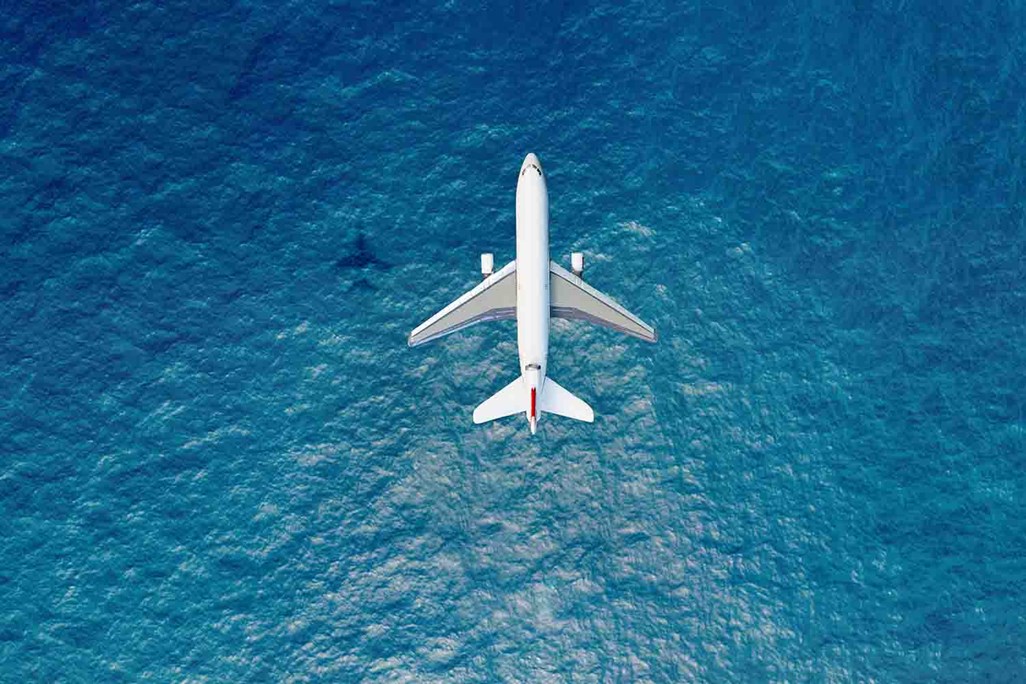 Solo Cargo Airplane Flying Over Blue Ocean
