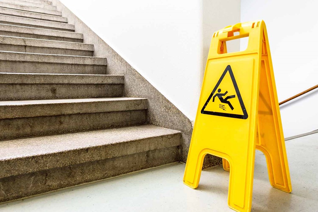 Caution slippery surface sign at Stairs Inside Commercial Building