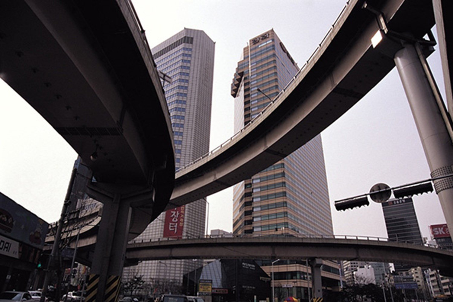 Looking up at highway overpasses and high-rise buildings