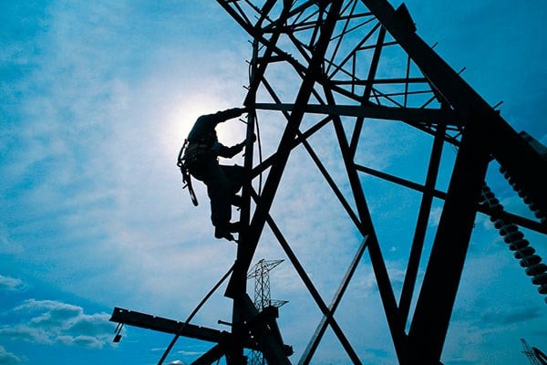 silhouette of man climbing steel tower