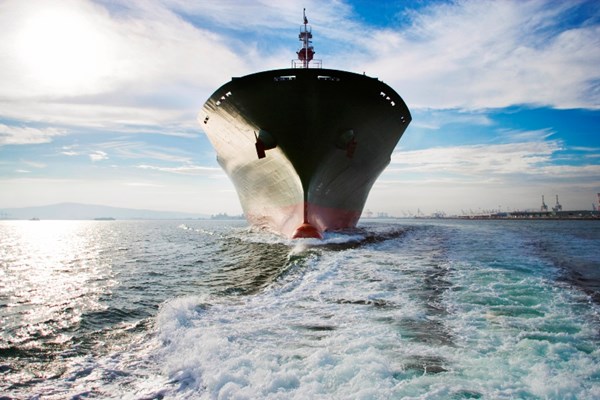 Bow view of cargo ship sailing out of port