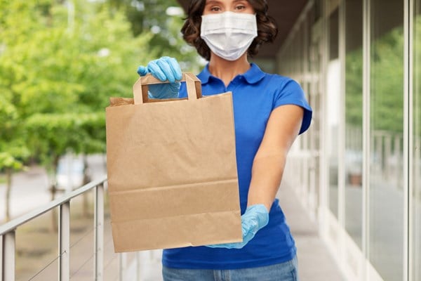woman wearing a medical mask making a delivery