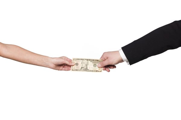 Two hands pulling a $10 bill between them