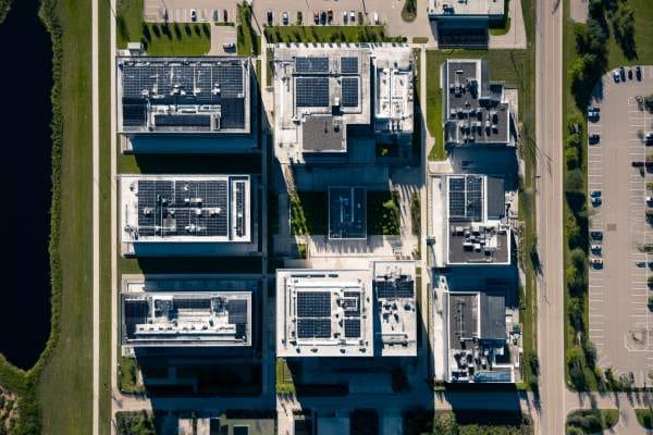 overhead view of a new group of high-tech buildings between a water feature and a parking lot