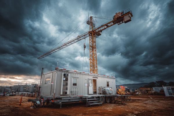 an office on a construction site under a crane on a cloudy day