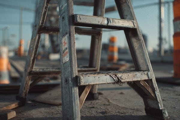 cracked rungs on a step ladder at a construction site