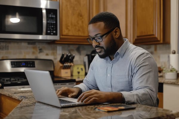A businessman working on his laptop in his kitchen
