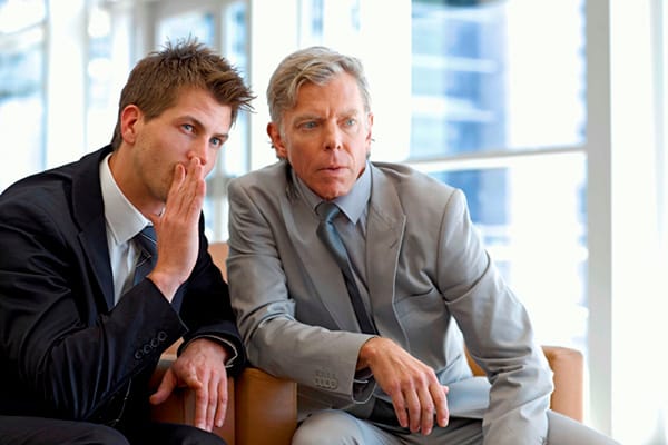 Businessmen whispering