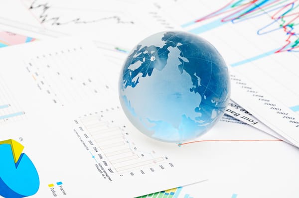 Globe on top of financial charts and graphs