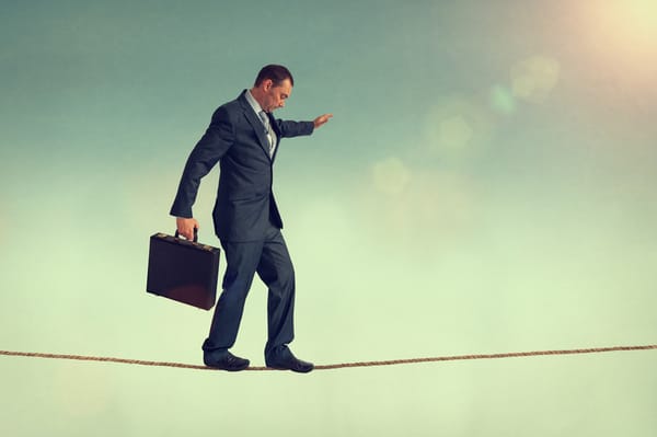 Businessman with a suitcase on a tightrope