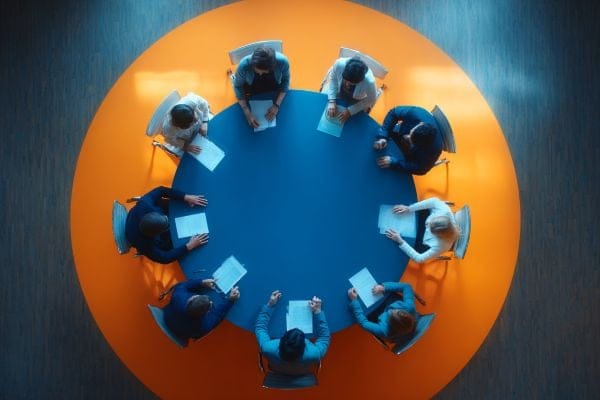 Overhead view of business professionals negotiating at a round conference table
