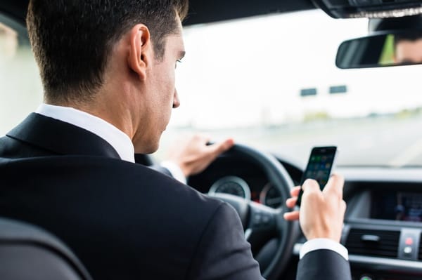 Businessman texting and driving