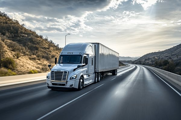 A semi truck drives on an empty highway