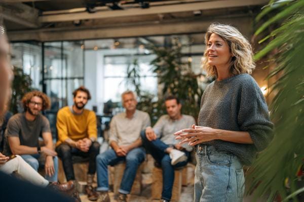 mental health professional speaking to a group of businesspeople in a casual setting