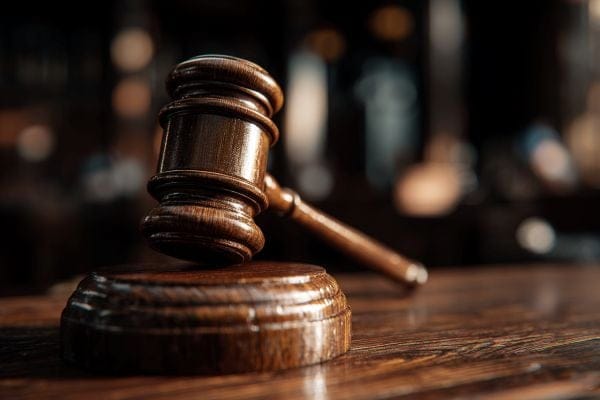 wooden gavel balanced on a wooden table